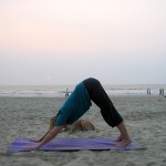 Eine Frau macht Yoga am Strand